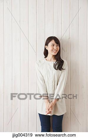 Young Japanese woman against wooden wall View Large Photo Image Stock Photo - Young Japanese woman against wooden wall. Fotosearch
