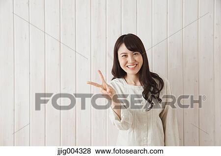 Young Japanese woman against wooden wall View Large Photo Image Stock Photo - Young Japanese woman against wooden wall. Fotosearch