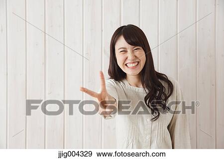 Young Japanese woman against wooden wall View Large Photo Image Stock Photo - Young Japanese woman against wooden wall. Fotosearch