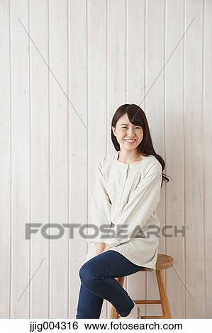 Young Japanese woman against wooden wall View Large Photo Image Stock Photograph - Young Japanese woman against wooden wall. Fotosearch
