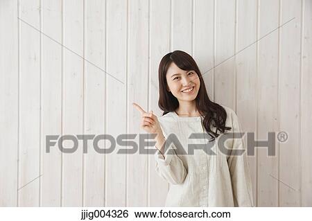 Young Japanese woman against wooden wall View Large Photo Image Stock Photograph - Young Japanese woman against wooden wall. Fotosearch