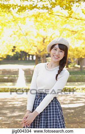 Picture - Young Japanese woman in a city park. Fotosearch