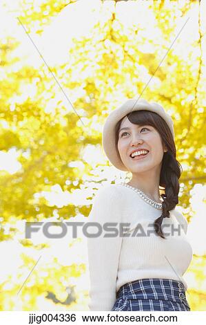 Young Japanese woman in a city park View Large Photo Image Stock Photograph - Young Japanese woman in a city park. Fotosearch