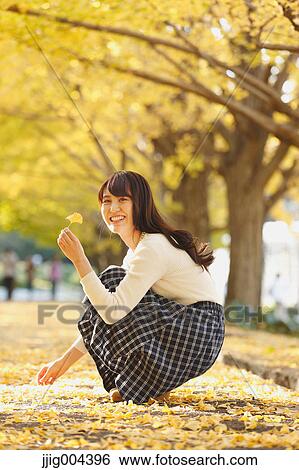 Young Japanese woman in a city park View Large Photo Image Stock Photograph - Young Japanese woman in a city park. Fotosearch