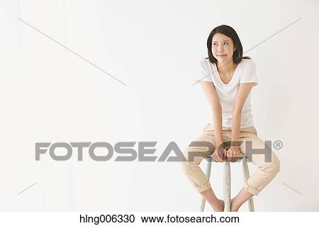 Young Japanese woman on a chair in a white room View Large Photo Image Stock Image - Young Japanese woman on a chair in a white room. Fotosearch