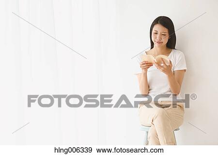 Young Japanese woman on a chair in a white room View Large Photo Image Stock Photo - Young Japanese woman on a chair in a white room. Fotosearch