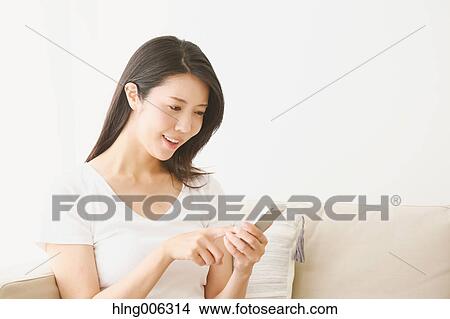 Young Japanese woman on the sofa in a white room View Large Photo Image Picture - Young Japanese woman on the sofa in a white room. Fotosearch