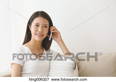 Young Japanese woman on the sofa in a white room View Large Photo Image Stock Photo - Young Japanese woman on the sofa in a white room. Fotosearch