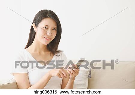 Young Japanese woman on the sofa in a white room View Large Photo Image Stock Photography - Young Japanese woman on the sofa in a white room. Fotosearch