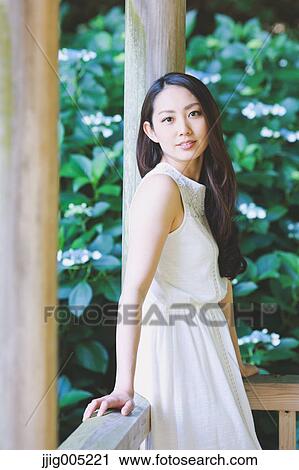 Young Japanese woman on wooden deck in a city park View Large Photo Image Stock Image - Young Japanese woman on wooden deck in a city park. Fotosearch
