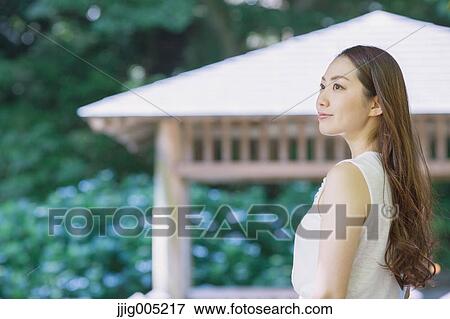 Young Japanese woman on wooden deck in a city park View Large Photo Image Stock Photo - Young Japanese woman on wooden deck in a city park. Fotosearch