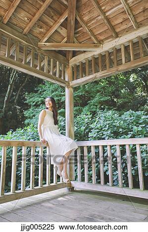Young Japanese woman on wooden deck in a city park View Large Photo Image Stock Photography - Young Japanese woman on wooden deck in a city park. Fotosearch