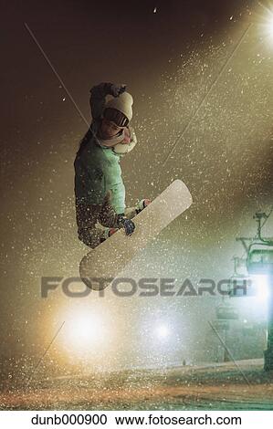 Stock Image - Young Japanese woman snowboarding. Fotosearch