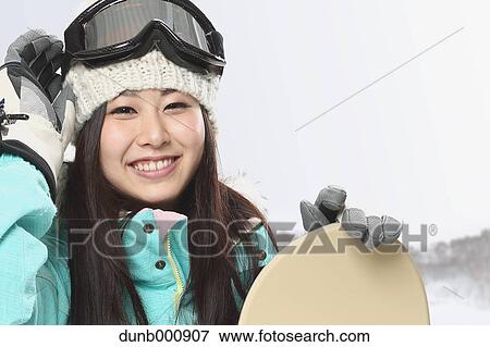 Stock Photo - Young Japanese woman snowboarding. Fotosearch