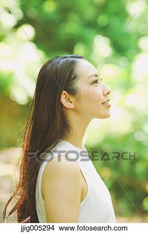 Young Japanese woman surrounded by green in a city park View Large Photo Image Picture - Young Japanese woman surrounded by green in a city park. Fotosearch