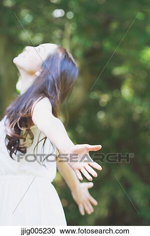 Young Japanese woman surrounded by green in a city park View Large Photo Image Stock Image - Young Japanese woman surrounded by green in a city park. Fotosearch