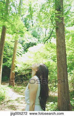 Young Japanese woman surrounded by green in a city park View Large Photo Image Stock Image - Young Japanese woman surrounded by green in a city park. Fotosearch