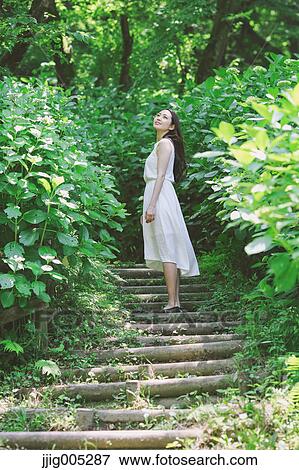 Young Japanese woman surrounded by green in a city park View Large Photo Image Stock Photo - Young Japanese woman surrounded by green in a city park. Fotosearch