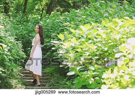 Young Japanese woman surrounded by green in a city park View Large Photo Image Stock Photo - Young Japanese woman surrounded by green in a city park. Fotosearch