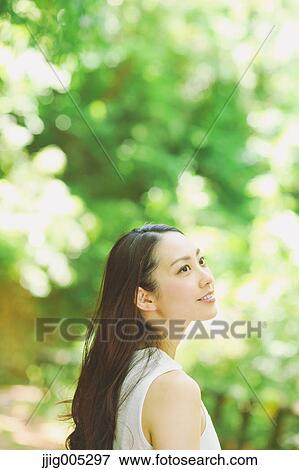 Young Japanese woman surrounded by green in a city park View Large Photo Image Stock Photo - Young Japanese woman surrounded by green in a city park. Fotosearch