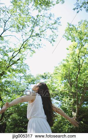 Young Japanese woman surrounded by green in a city park View Large Photo Image Stock Photo - Young Japanese woman surrounded by green in a city park. Fotosearch