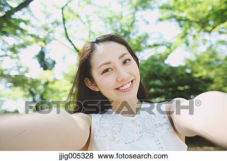 Young Japanese woman surrounded by green in a city park View Large Photo Image Stock Photo - Young Japanese woman surrounded by green in a city park. Fotosearch