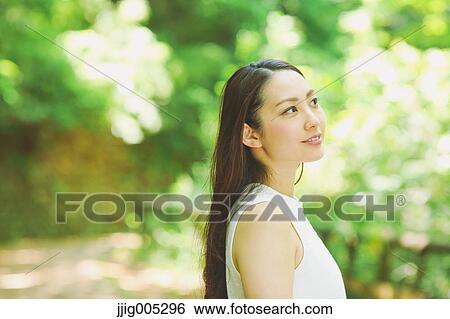 Young Japanese woman surrounded by green in a city park View Large Photo Image Stock Photograph - Young Japanese woman surrounded by green in a city park. Fotosearch