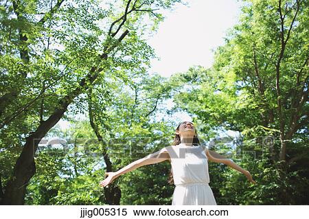 Young Japanese woman surrounded by green in a city park View Large Photo Image Stock Photography - Young Japanese woman surrounded by green in a city park. Fotosearch