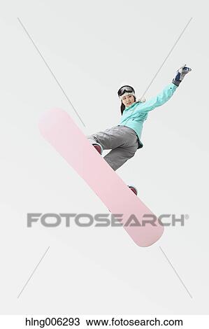 Stock Image - Young Japanese woman wearing snowboard wear on white background. Fotosearch