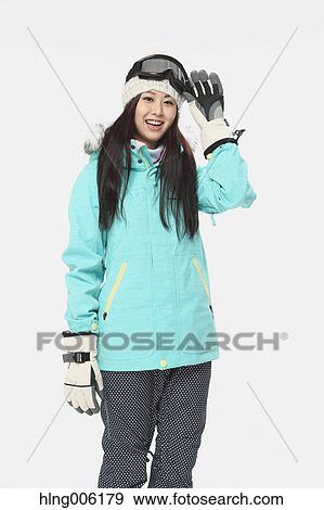 Stock Photo - Young Japanese woman wearing snowboard wear on white background. Fotosearch