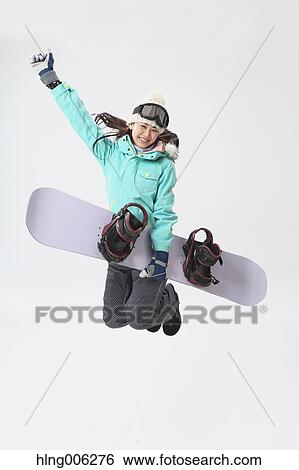 Stock Photograph - Young Japanese woman wearing snowboard wear on white background. Fotosearch