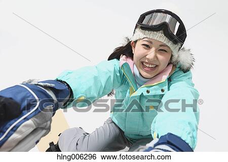 Stock Photograph - Young Japanese woman wearing snowboard wear on white background. Fotosearch