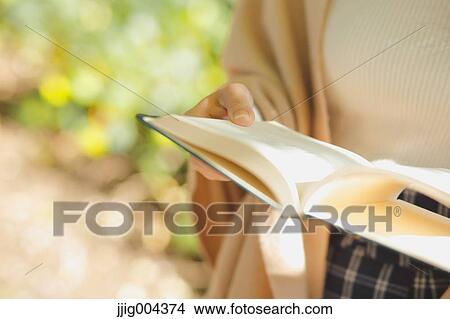 Young Japanese woman with book in a city park View Large Photo Image Picture - Young Japanese woman with book in a city park. Fotosearch