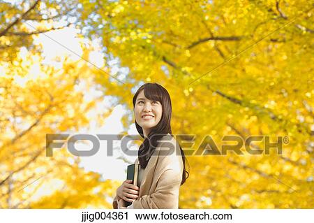 Young Japanese woman with book in a city park View Large Photo Image Stock Image - Young Japanese woman with book in a city park. Fotosearch