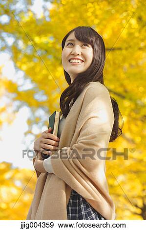 Young Japanese woman with book in a city park View Large Photo Image Stock Photo - Young Japanese woman with book in a city park. Fotosearch