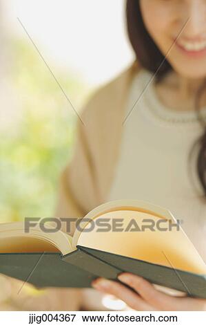 Young Japanese woman with book in a city park View Large Photo Image Stock Photo - Young Japanese woman with book in a city park. Fotosearch