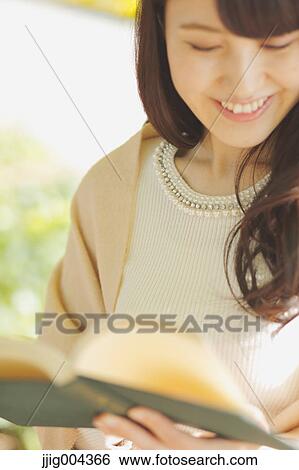 Young Japanese woman with book in a city park View Large Photo Image Stock Photograph - Young Japanese woman with book in a city park. Fotosearch