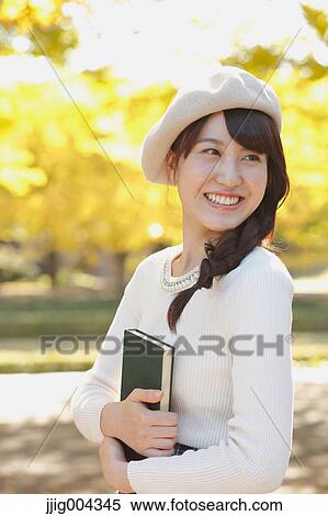 Young Japanese woman with book in a city park View Large Photo Image Stock Photography - Young Japanese woman with book in a city park. Fotosearch