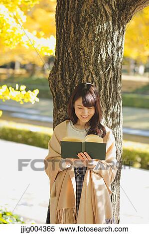 Young Japanese woman with book in a city park View Large Photo Image Stock Photography - Young Japanese woman with book in a city park. Fotosearch