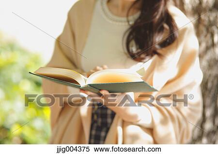 Young Japanese woman with book in a city park View Large Photo Image Stock Photography - Young Japanese woman with book in a city park. Fotosearch
