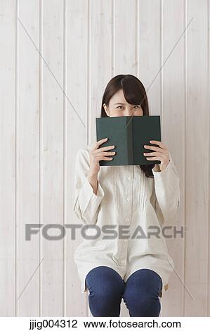 Stock Image - Young Japanese woman with book. Fotosearch