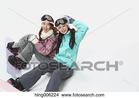 Picture - Young Japanese women wearing snowboard wear on white background. Fotosearch
