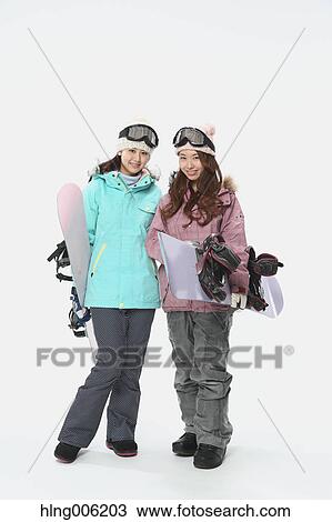 Stock Image - Young Japanese women wearing snowboard wear on white background. Fotosearch