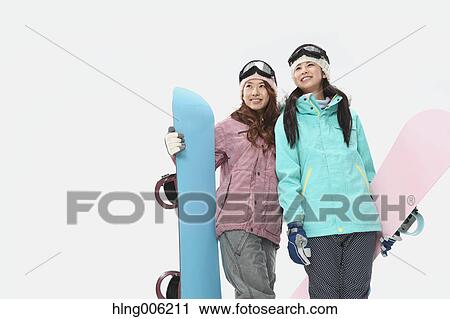 Stock Image - Young Japanese women wearing snowboard wear on white background. Fotosearch