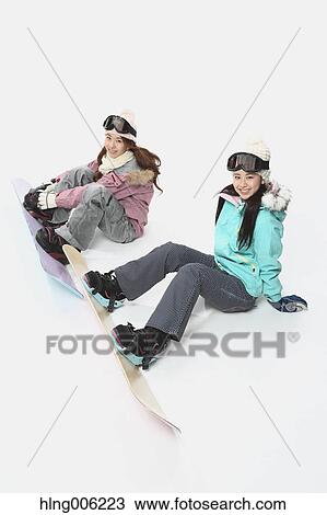Stock Image - Young Japanese women wearing snowboard wear on white background. Fotosearch