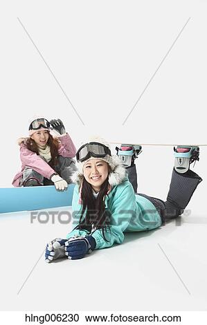 Stock Image - Young Japanese women wearing snowboard wear on white background. Fotosearch