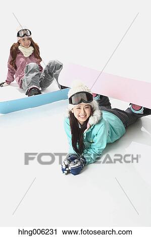Stock Image - Young Japanese women wearing snowboard wear on white background. Fotosearch