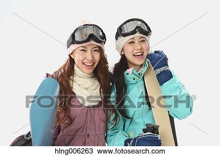 Stock Image - Young Japanese women wearing snowboard wear on white background. Fotosearch