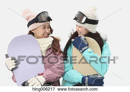 Stock Photo - Young Japanese women wearing snowboard wear on white background. Fotosearch