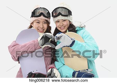 Stock Photo - Young Japanese women wearing snowboard wear on white background. Fotosearch